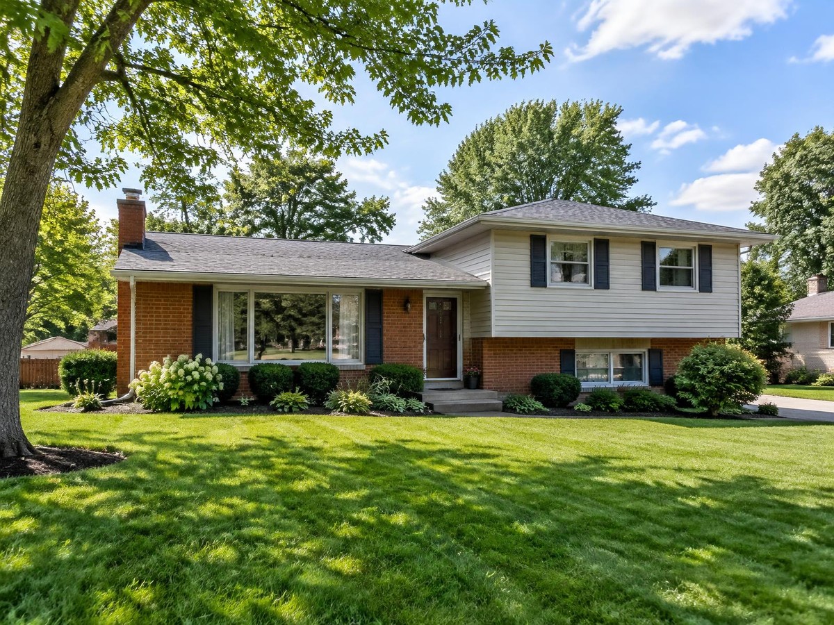A tidy suburban split-level house on a sunny day.