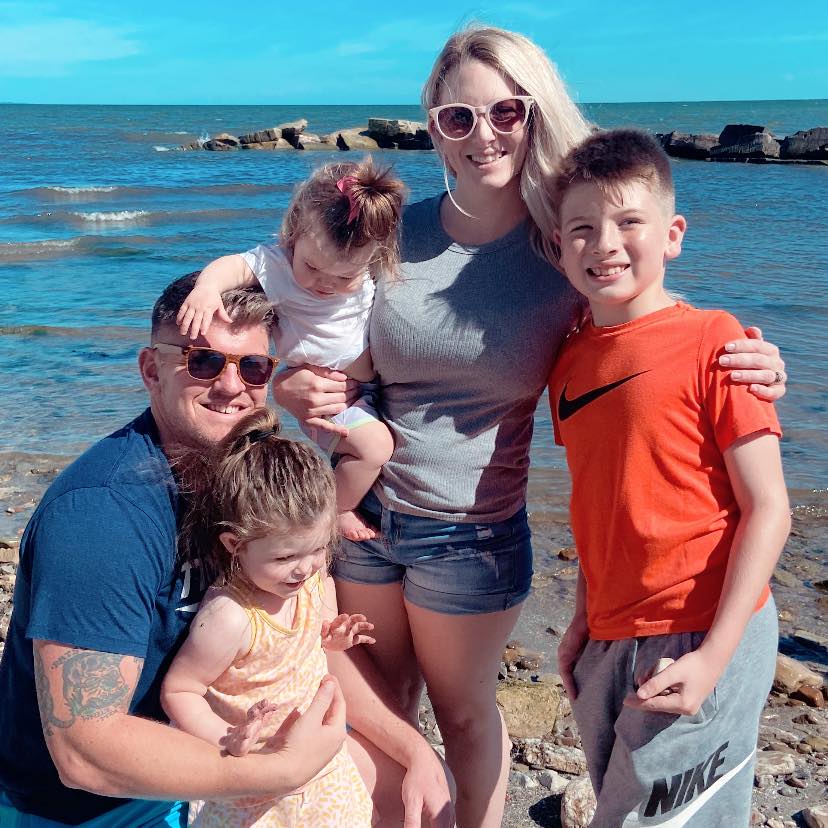 Phil Arthur, founder of RC Home Buyers, with his family on a Lake Erie shoreline.